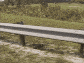 a white and black railing on the side of a road with a golf course in the background
