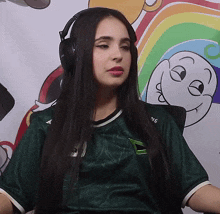 a woman wearing headphones and a green shirt that says mg on it