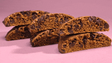 a stack of cookies with chocolate chips on a pink surface