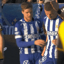 a soccer player wearing a blue and white striped jersey with the word ernek on it