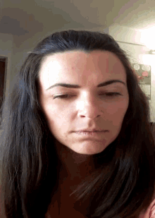 a woman 's face is shown with her eyes closed and a pink shirt on