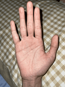a close up of a person 's hand on a bed