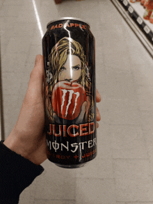 a person holding a can of juiced monster