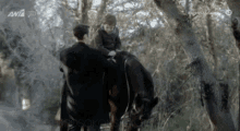 a man and a boy riding a horse in the woods with a tv screen behind them that says anta