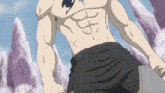 a man without a shirt is standing in front of a mountain