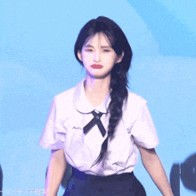 a girl wearing a white shirt with a black x on the collar