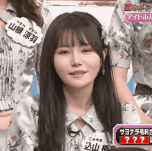 a woman in a floral shirt has a name tag that says ' yama ' on it