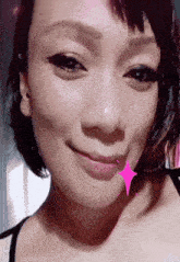a close up of a woman 's face with a pink star around her mouth