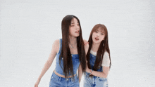 two girls are playing with each other 's hair and smiling .