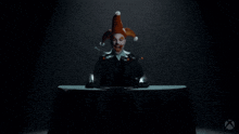 a man dressed as a clown is sitting at a table