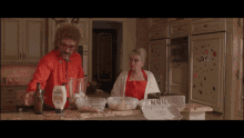 a man and a woman are preparing food in a kitchen