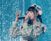 a girl singing into a microphone wearing a plaid shirt and hat