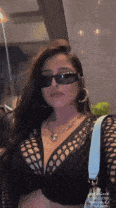 a woman wearing sunglasses and a black crop top