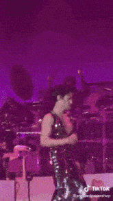 a person is dancing on a stage in front of a purple background .