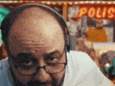 a man wearing glasses and headphones looks at the camera in front of a sign that says polio