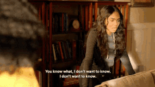 a woman standing next to a couch with the words you know what i don 't want to know