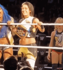 a woman in a wrestling ring holding a trophy and smiling