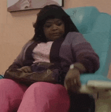 a woman sits in a chair with the number 3 on the back