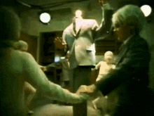 a man in a suit is standing next to a woman in a white shirt in a room .