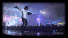 a man stands on a stage in front of a crowd with a jup entertainment logo