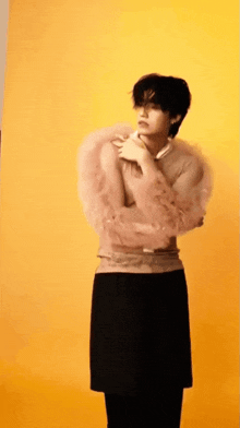 a man wearing a sweater with ruffled sleeves and a black skirt