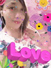 a woman is surrounded by flowers and confetti with the word love above her