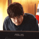 a man sits in front of an asus monitor