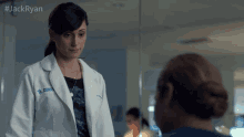 a woman in a lab coat with the name jack ryan on the front