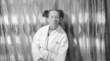 a black and white photo of a woman wearing a white robe that says ' a few dollars ' on it