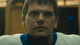 a close up of a man 's face with the hulu logo in the background