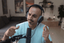 a man wearing headphones giving a thumbs up sign