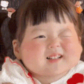 a baby girl is making a funny face with her eyes closed and her mouth open .