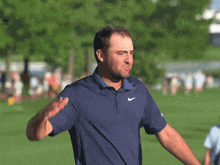 a man wearing a blue nike shirt is waving