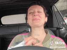 a woman in a car with a tattoo on her neck that says " heaven "