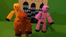 three toy figures are standing next to each other on a green background