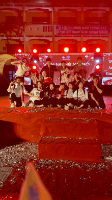 a group of people posing for a picture in front of a sign that says vi locich muoi nam trong co
