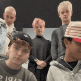 a group of young men are posing for a picture with one wearing a hat that says ny on it