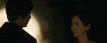 a man and woman are kissing in the dark
