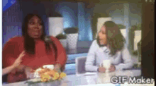 two women sitting at a table with a gif maker watermark
