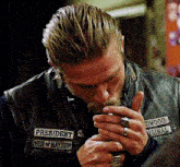 a man wearing a leather vest with president men of mayhem written on it