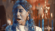 a woman with blue hair and the word ironheart on her face