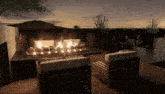 a fire pit is lit up in the middle of a patio