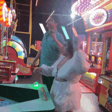 a man and a woman are playing a game in an arcade with a sign that says ' lucky strike '