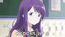 a girl with purple hair is sitting in a classroom with a blackboard behind her .