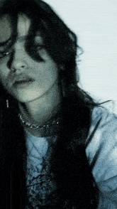 a close up of a woman 's face with a necklace around her neck