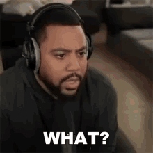 a man wearing headphones is sitting down and making a funny face .