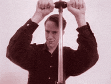 a man in a black shirt is holding a metal object