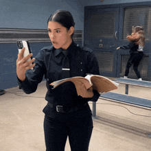 a woman in a police uniform is taking a selfie with her phone