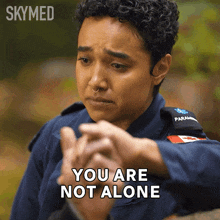 a female paramedic says " you are not alone " while holding another person 's hand
