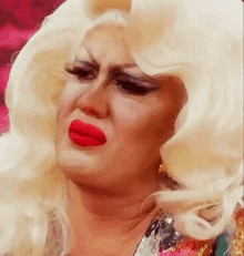 a drag queen with blonde hair and red lips